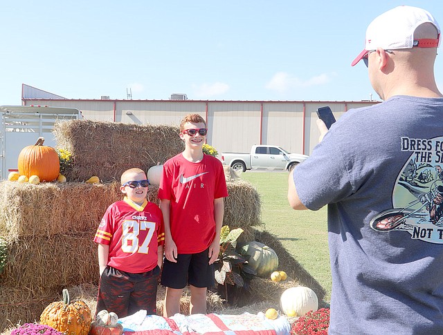 LYNN KUTTER ENTERPRISE-LEADER Doug Chambers of Farmington snaps a photo of his sons Blaine Chambers, 13, and Brett Chambers, 7, at the Farmington Fall Festival.