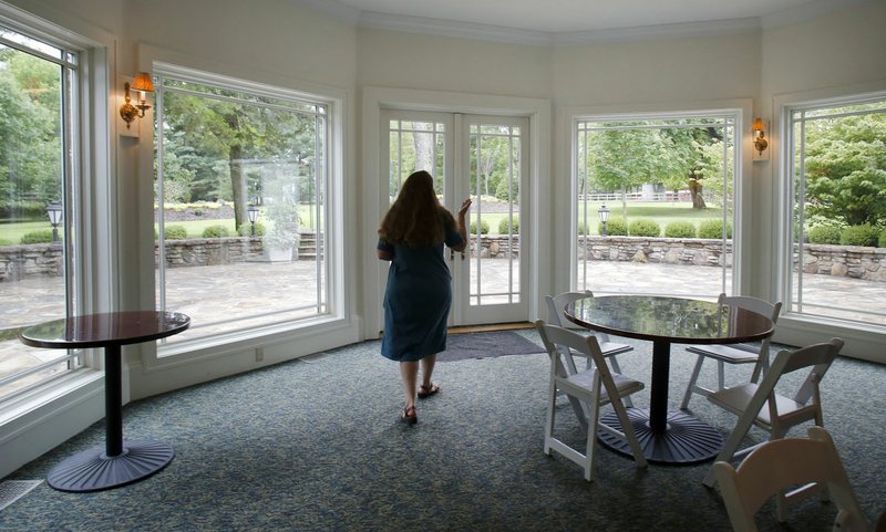 File photo/NWA Democrat-Gazette/DAVID GOTTSCHALK Sarah King, marketing director for Specialized Real Estate, walks through the large gathering room Aug. 8 at the Pratt Place Inn on Markham Hill in Fayetteville. Specialized Real Estate has plans to develop sections of the hill.