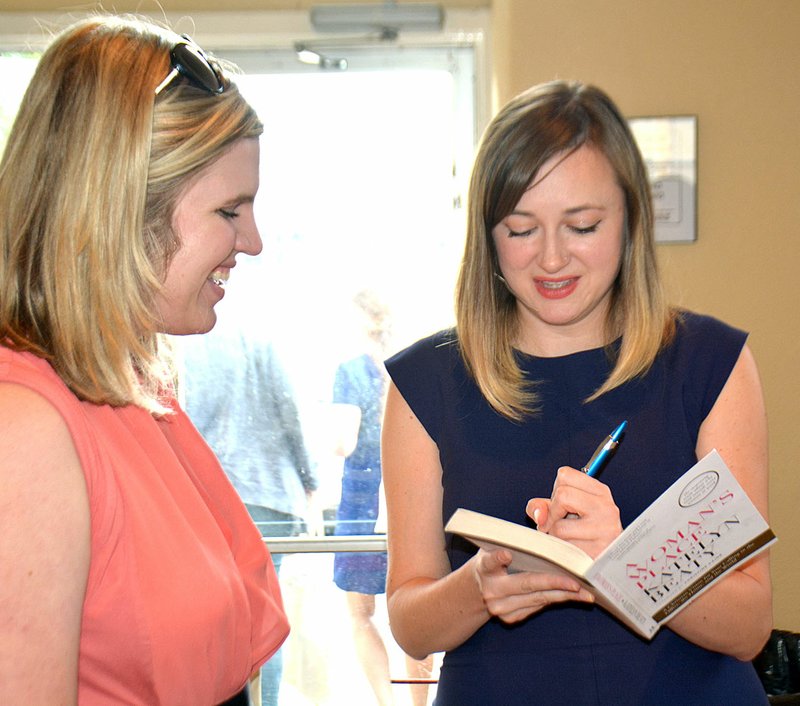 Janelle Jessen/Herald-Leader Author Katelyn Beaty signed a copy of her book for Stephanie Red of Bentonville. Beaty spoke at the Women's Leadership Forum Lunch and Learn event, held at the Siloam Springs Community Building on Tuesday. The event was hosted by DaySpring Cards and sponsored by a number of local businesses.