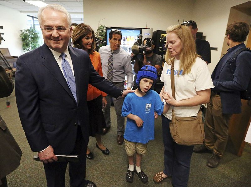 Jack Gerard (left), a leader in the Mormon church, stands with Heather Nelson and her son Matthew, 10, after an August news conference in Salt Lake City on Utah’s medical marijuana ballot initiative. 