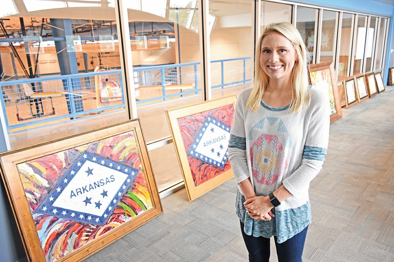 Jessica Franklin, the special events coordinator for the Boys & Girls Clubs of Saline County, stands in front of artwork created by local artist Matt Coburn. Coburn donated four oil paintings that will be sold during the sixth annual Night to Become. The event, set for 5 p.m. Oct. 16, will also feature country-music artist Justin Moore.