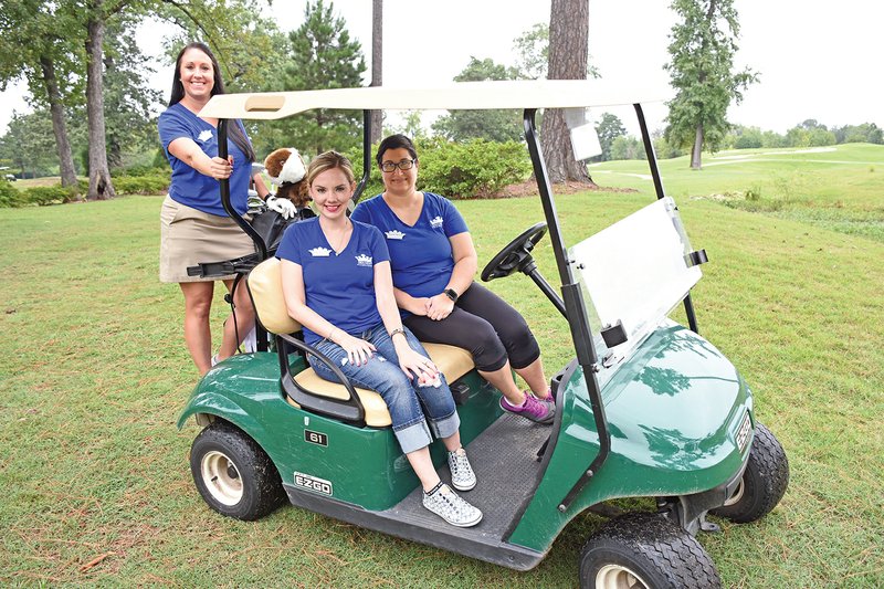 Tisha Mills, standing, co-chairwoman of the Junior Auxiliary of Saline County’s upcoming Putt the Kids First Golf Tournament, played in last year’s tournament and plans to do so again this year. Accompanying her on a visit to the Hurricane Golf and Country Club are fellow JA members Rachel Washington, seated, front, and Angela Hebert, back.