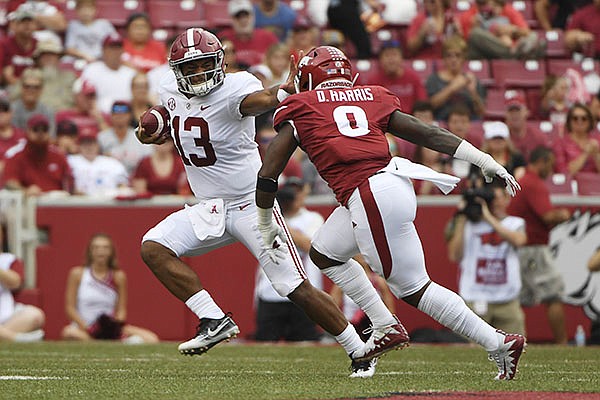 Alabama quarterback Tua Tagovailoa (13) tries to get away from Arkansas defender De'Jon Harris in the first half of an NCAA college football game Saturday, Oct. 6, 2018, in Fayetteville, Ark. (AP Photo/Michael Woods)
Alabama quarterback Tua Tagovailoa (13) tries to get away from Arkansas defender De'Jon Harris in the first half of an NCAA college football game Saturday, Oct. 6, 2018, in Fayetteville, Ark. (AP Photo/Michael Woods)