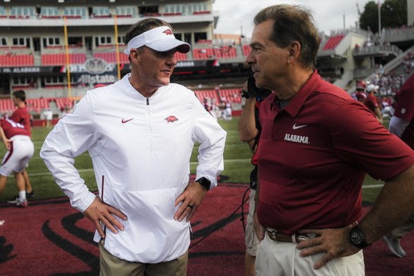 Arkansas coach Chad Morris (left) and Alabama coach Nick Saban speak prior to a game Saturday, Oct. 6, 2018, in Fayetteville.