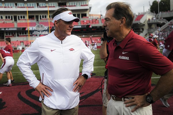 Arkansas coach Chad Morris (left) and Alabama coach Nick Saban speak prior to a game Saturday, Oct. 6, 2018, in Fayetteville. 