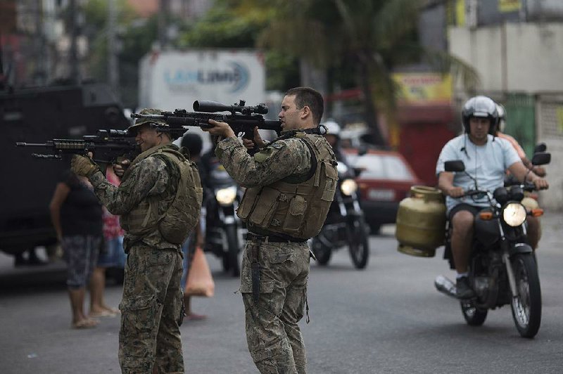 Brazilian police officers aim their weapons during an operation in a slum in Rio de Janeiro ahead of today’s general elections.