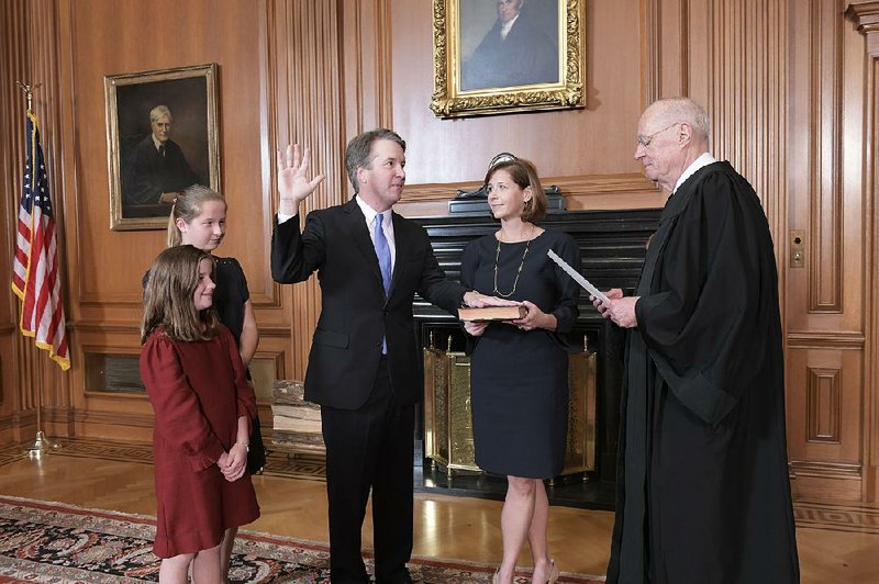 Retired Supreme Court Justice Anthony Kennedy administers the judicial oath on Saturday to his successor, Brett Kavanaugh, in the Supreme Court Building in Washington as Kavanaugh’s wife, Ashley, holds the Bible.