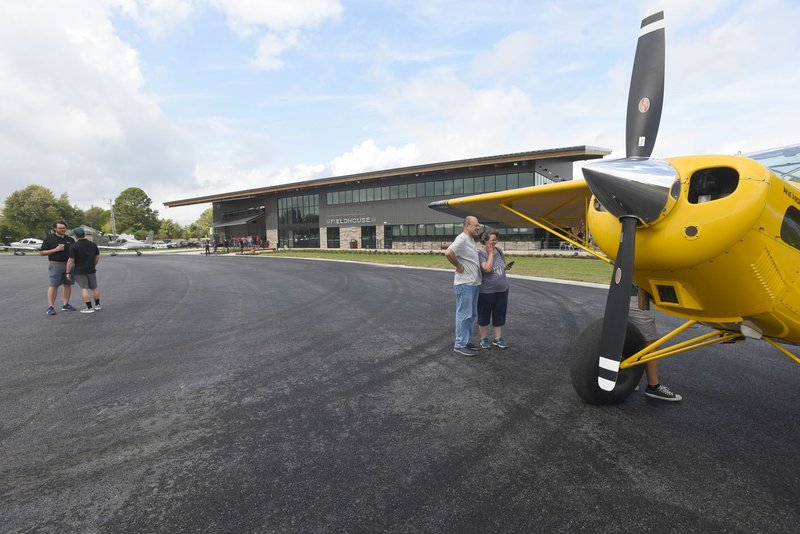 Visitors on Saturday look at aircraft during the opening of Thaden Fieldhouse at the Bentonville airport. The fieldhouse along Southwest I Street features an exhibit hangar, porches that overlook the runway, a cafe and retail shop. It is also home of the OZ1 Flying Club.