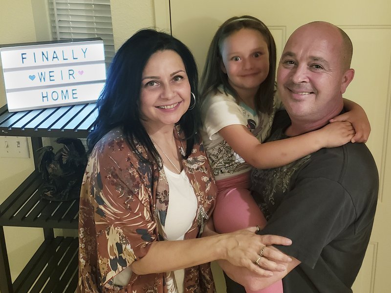 The Weir family, Vennita, left, Athena, center, and Bill take a photograph, at their home on Wednesday, September 27, 2018, in Albuquerque, N.M. Military families are complaining that this year&#x2019;s base transfers are the worst in memory as movers are destroying, damaging, losing and stealing their household goods.  (Vennita Weir, Source via AP)