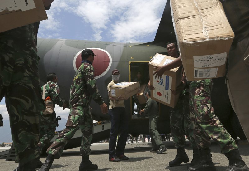 Indonesian and Japan military personnel unload relief aid from a Japan Air Force cargo plane at the Mutiara Sis Al-Jufri airport in Palu, Central Sulawesi, Indonesia, Saturday, Oct. 6, 2018. A 7.5 magnitude earthquake rocked the city on Sept. 28, triggering a tsunami and mud slides that killed a large number of people and displaced tens of thousands others. (AP Photo/Tatan Syuflana)