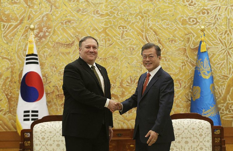 South Korean President Moon Jae-in (right) greets U.S. Secretary of State Mike Pompeo during a meeting at the presidential Blue House on Sunday in Seoul, South Korea. 