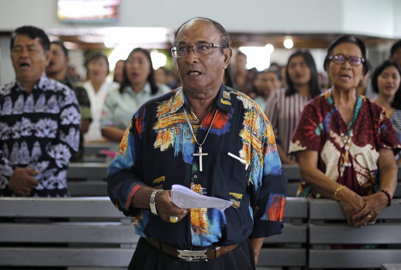 Christians sing inside a church at the earthquake and tsunami-hit town of Palu, Central Sulawesi, Indonesia Sunday, Oct. 7, 2018. Christians dressed in their tidiest clothes flocked to Sunday sermons in the earthquake and tsunami damaged Indonesian city of Palu, hoping for answers to the double tragedy that inflicted deep trauma on their community. (AP Photo/Aaron Favila)