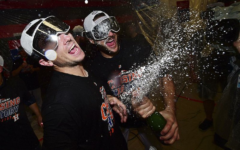 Alex Bregman (left) and Jake Marisnick celebrate after the Hous- ton Astros defeated the Cleveland Indians 11-3 in Game 3 of the American League division series Monday in Cleveland.