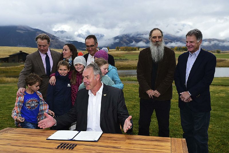 People gather around Interior Secretary Ryan Zinke on Monday in Pray, Mont., as he signs the mining moratorium for lands in the Paradise Valley, north of Yellowstone National Park.