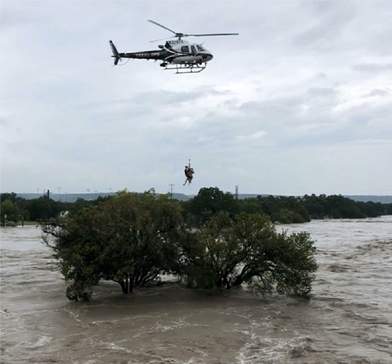 A helicopter crew from the Texas Department of Public Safe- ty performs a rescue from the flooded South Llano River near Junction, Texas, on Monday.