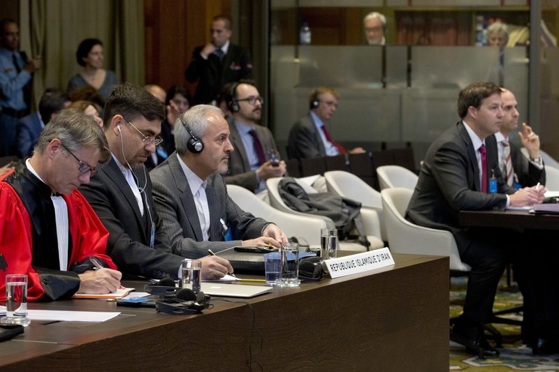 In this Wednesday Oct. 3, 2018, image Mohammed Zahedin Labbaf, third left, agent for the Islamic Republic of Iran, and the U.S. delegation, right, listen to the ruling of the judges on an Iranian request to order Washington to suspend sanctions against Tehran, at the International Court of Justice, or World Court, in The Hague, Netherlands. The U.S. is urging the United Nations' highest court Monday Oct. 8, 2018, to toss out a case filed by Iran that seeks to recover around $2 billion worth of frozen assets the U.S. Supreme Court awarded to victims of a 1983 bombing in Lebanon and other attacks linked to Iran.(AP Photo/Peter Dejong)