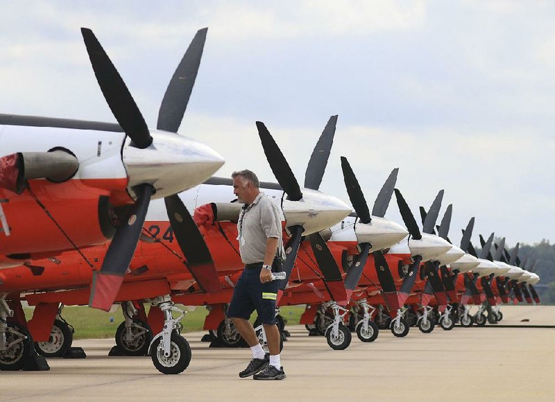 Danny York, line manager for TAC Air at Bill and Hillary Clinton National Airport/Adams Field, checks on a line of T-6 Texan II aircraft Tuesday at the airport. About 50 of the U.S. Navy primary trainers were expected to arrive from Naval Air Station Whiting Field in Florida as Hurricane Michael neared the coast.