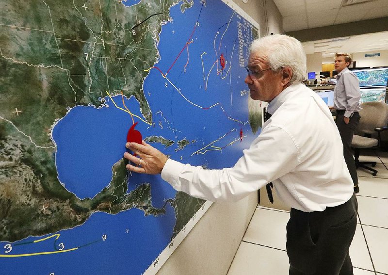 Dennis Feltgen with the National Oceanic and Atmospheric Administration updates the progress Tuesday of fast-moving Hurricane Michael at the Hurricane Center in Miami. 
