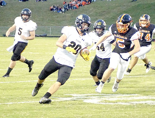RANDY MOLL NWA NEWSPAPERS Prairie Grove senior Garrett Heltemes carries the football during first quarter at Gravette. Heltemes scored twice on short runs against Shiloh Christian, but the Tigers were routed 56-14 Friday.