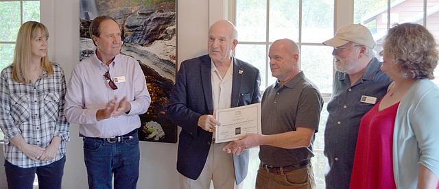 Keith Bryant/The Weekly Vista Bella Vista Arts Council member Demara Titzer (left) stands next to Dave Barfield while mayor Peter Christie hands Silas Byers III a certificate recognizing him as the Bella Vista Arts Council featured artist for September Terry Wilson and Sara Parnell look on.