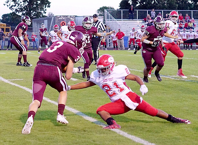 Westside Eagle Observer/RANDY MOLL After catching a pass from Gentry's junior quarterback Brandon Atwood, Peyton Wright, a Gentry senior, tries to get past Green Forest opponents during Friday night's homecoming game at Gentry High School.