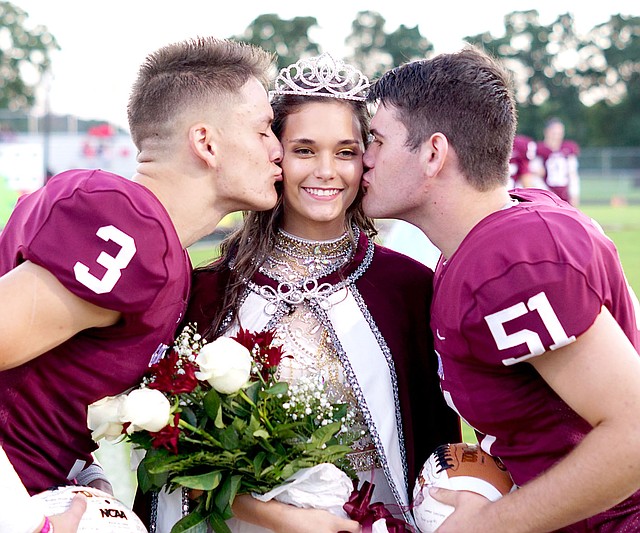 Westside Eagle Observer/RANDY MOLL Homecoming captains Peyton Wright and Garrett Hays kiss queen Danielle Spencer on the cheek at homecoming ceremonies at Gentry High School on Friday, Oct. 5, 2018.