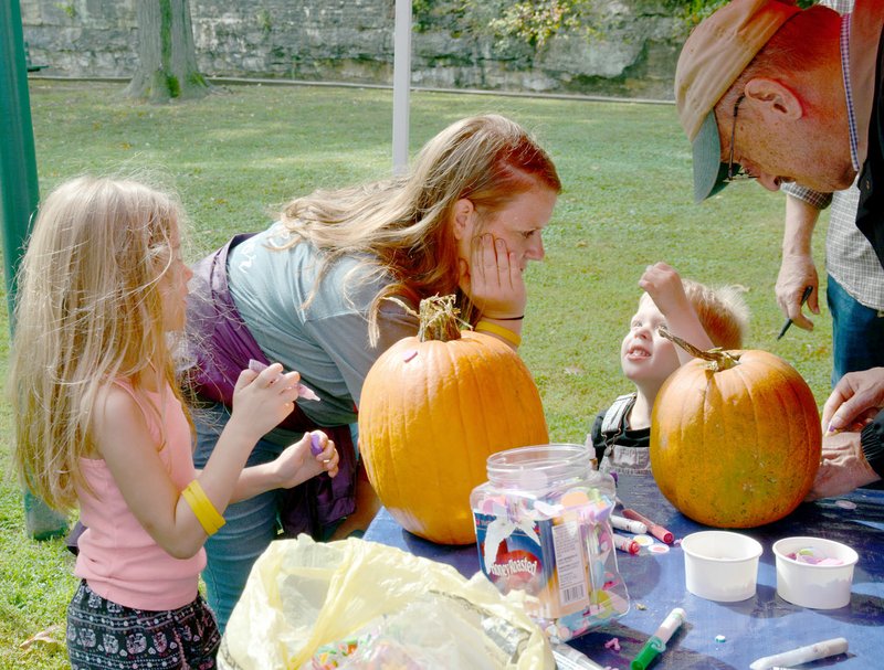Janelle Jessen/Herald-Leader Conner Bedor, center, helped her niece Rowan, left, and nephew Mason, decorate pumpkins.