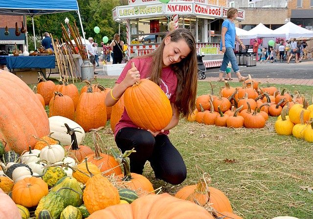 Janelle Jessen/Herald-Leader Abbey Johnson of Siloam Springs picked out the perfect pumpkin at the pumpkin patch, owned by Kevin Edmondson of Gentry, during the Homegrown Festival in downtown Siloam Springs on Saturday. For more pictures of the festival, see page 6A.