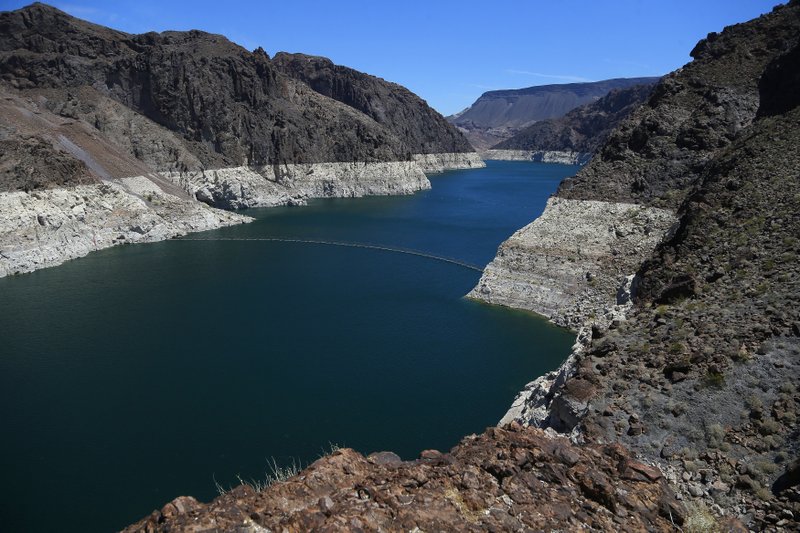In this May 31, 2018, file photo, the low level of the water line is shown on the banks of the Colorado River in Hoover Dam, Ariz. Seven Southwestern U.S. states that depend on the overtaxed Colorado River say they have reached tentative agreements on managing the waterway amid an unprecedented drought. (AP Photo/Ross D. Franklin, File)