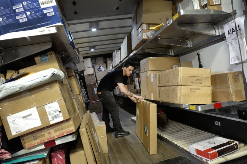 In this May 2017 file photo, a UPS employee loads packages onto a truck at a company facility in New York. The job market is the tightest it has been in nearly five decades and online shopping is still growing at a double-digit rate. Businesses now need more workers at a time when fewer are available. UPS plans to hold nearly 170 job fairs around the country on a single day, Oct. 19. (AP Photo/Mark Lennihan, File)

