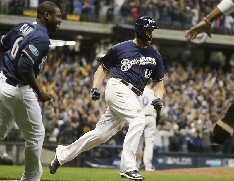 Third baseman Mike Moustakas (right) has been a hit with fans and teammates since joining the Milwaukee Brewers two months ago. Moustakas and Lorenzo Cain (left) helped the Kansas City Royals win a World Series in 2015 and they’re one step away from a return as they take on the Los Angeles Dodgers in the National League Championship Series.