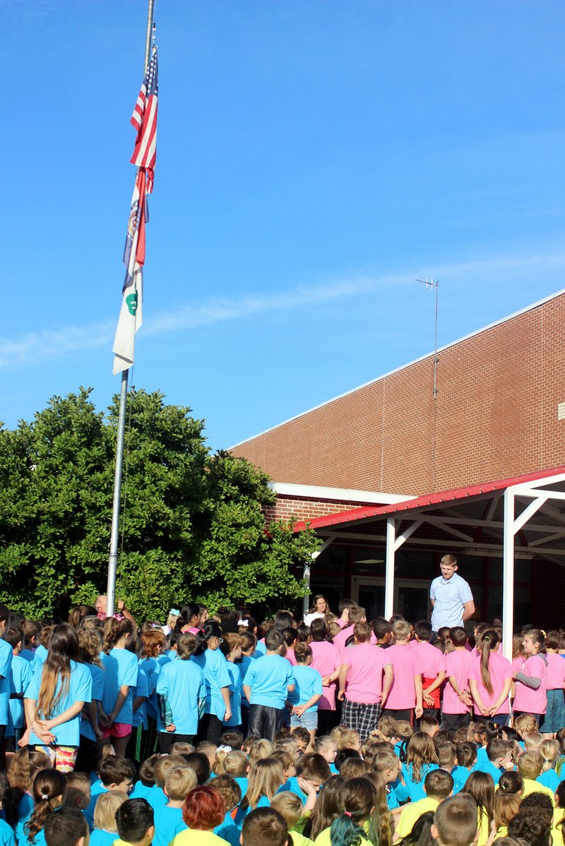 MEGAN DAVIS/MCDONALD COUNTY PRESS Eli Jones, 4-H youth program specialist, leads students at Anderson Elementary in the 4-H pledge following the first raising of the 4-H flag on campus.