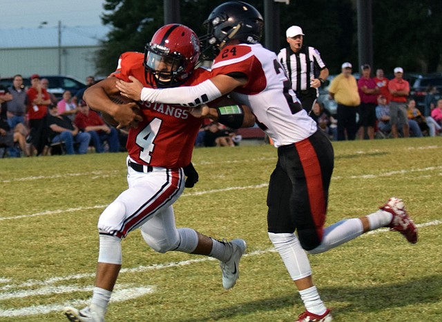 RICK PECK/SPECIAL TO MCDONALD COUNTY PRESS McDonald County quarterback Ben Mora (4) tries to fight free from a tackle by Lamar's Landon Hardman (24) during the Mustangs' 45-13 loss on Oct. 5 at MCHS. Mora finished with 47 rushing yards and added 120 yards through the air on 5 of 10 passing.