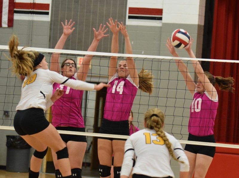 RICK PECK/SPECIAL TO MCDONALD COUNTY PRESS McDonald County's Mollie Milleson, Adyson Aanny and Katelyn Ferdig (left to right) form a triple block to stop a spike from Cassville's Sharayah Seymour during the Lady Mustangs' 25-14, 19-25, 25-17 loss on Oct. 4 at MCHS.