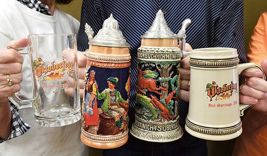 The Sentinel-Record/Grace Brown FESTIVE FARE: Event organizers display a few of the commemorative beer steins for the fourth annual Oktoberfest celebration in Hill Wheatley Plaza Friday and Saturday. The event is the primary fundraiser for the FACES Foundation.
