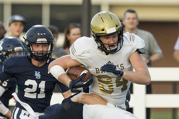 Hudson Henry, Pulaski Academy receiver, tries to break the tackle of Ty Copher (6), Springdale Har-Ber free safety, Friday, Aug. 24, 2018, during the game at Wildcat Stadium in Springdale.