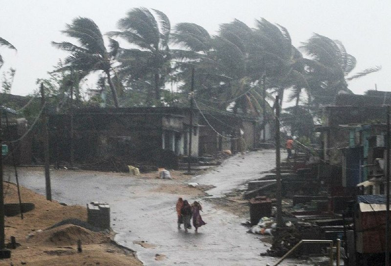 Villagers head for shelter Thursday near Gopalpur, India, as Cyclone Titli rages.