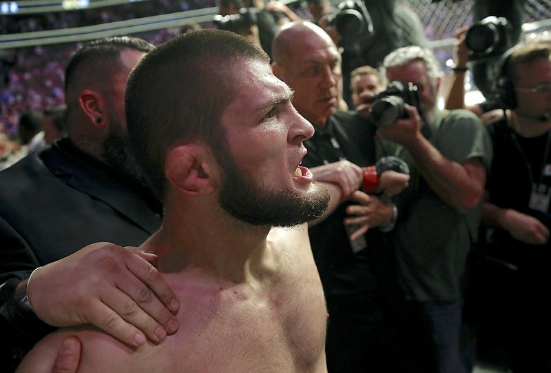 The Associated Press TITLE STRIFE: Khabib Nurmagomedov is held back Saturday outside of the cage after beating Conor McGregor in a lightweight title bout at UFC 229 in Las Vegas.