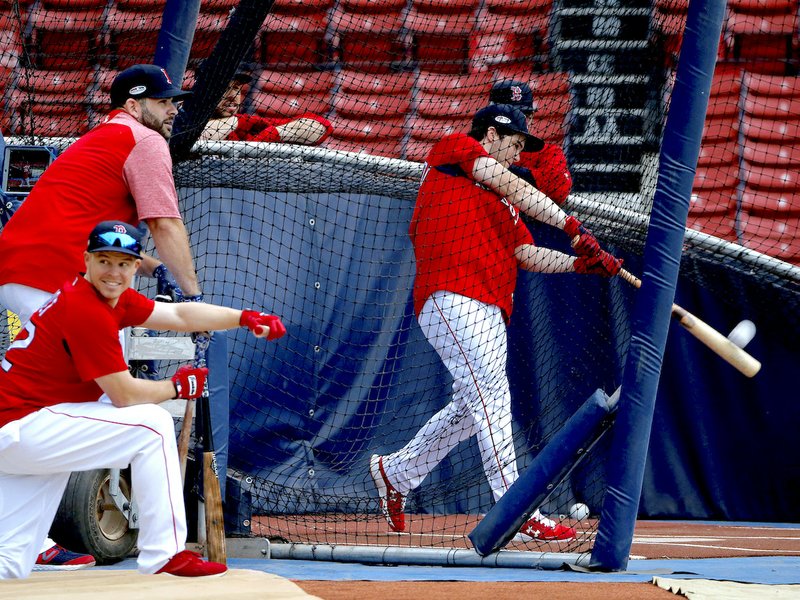 Boston Red Sox's Andrew Benintendi hits in the batting cage as teammates Mitch Moreland, left above, and Brock Holt, below, watch during a workout, Thursday, Oct. 11, 2018, in Boston. The Red Sox face the Houston Astros in Game 1 of baseball's American League Championship Series on Saturday at Boston's Fenway Park. (AP Photo/Elise Amendola)