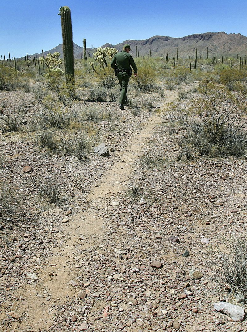 FILE - In this May 24, 2006, file photo, U.S. Border Patrol Senior Agent Sean King patrols a trail in Organ Pipe Cactus National Monument near Lukeville, Ariz. Smugglers in recent weeks have been abandoning large groups of Guatemalan and other Central American migrants in the desert near Arizona's boundary with Mexico, alarming Border Patrol officials who say the trend is putting hundreds of children and adults at risk. (AP Photo/Matt York)