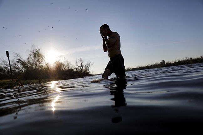 John Bird emerges from bathing in a lake after working all day to repair his damaged townhouse which has no running water in the aftermath of hurricane Michael in Parker, Fla., Thursday, Oct. 11, 2018. "Power I can do without," said Bird. "Water is another thing." (AP Photo/David Goldman)