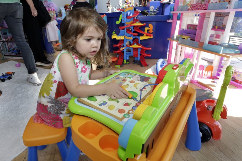 In this Aug. 30 photo, Seraphina, 3, plays with a V-Tech Explore and Write Activity Set at the Walmart Toy Shop event in New York. Walmart says 30 percent of its holiday toy assortment will be new. It will also offer 40 percent more toys on Walmart.com from a year ago. In November and December, the company’s toy area will be rebranded as “America’s Best Toy Shop.” (AP Photo/Richard Drew)

