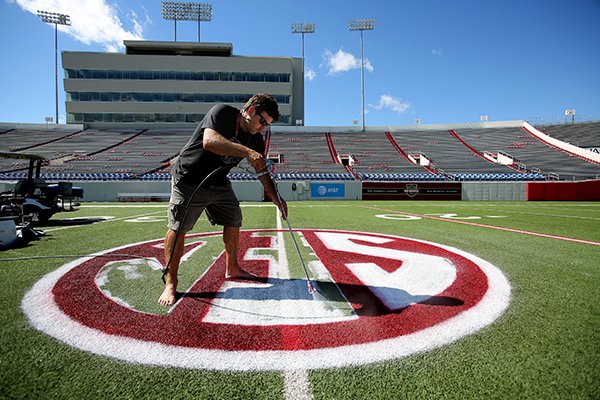 Josh Oliver paints the SEC logo on the field at War Memorial Stadium on Wednesday, Oct. 10, 2018, in Little Rock, in preparation for Saturday's football game between Arkansas and Ole Miss. As part of the new security measures for War Memorial Stadium no purses or backpacks are allowed, only clear bags, walk-through metal detectors and security wands will be at all entrances, and there is a prohibition against loitering in the concourse. The stadium opens at 4 p.m. and kickoff is scheduled for 6:30 p.m.

