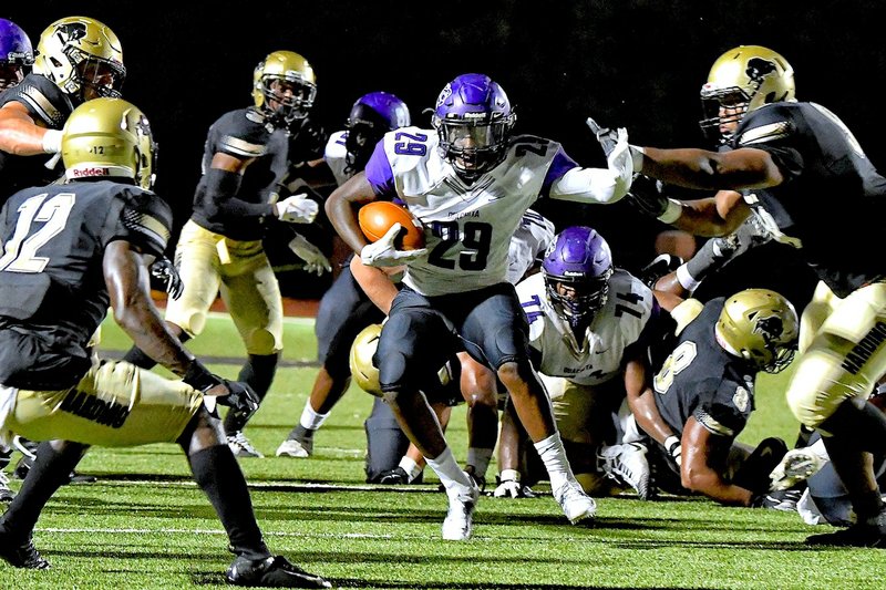 Submitted photo TIGERS RUN: Ouachita Baptist running back Shun'cee Thomas attempt to avoid a tackle during the Tigers' 7-3 victory over the Harding Bisons a week ago in Searcy. Photo by Jeff Montgomery, courtesy of Harding University Athletics.