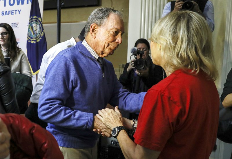 Former New York Mayor Michael Bloomberg talks to a woman who lost her daughter to gun violence after speaking at a rally at City Hall in Nashua, N.H. Saturday, Oct. 13, 2018. (AP Photo/ Cheryl Senter)