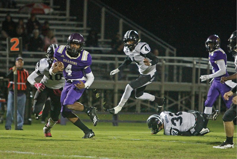 Terrance Armstard/News-Times Junction City's Jakiron Cook breaks free with Bearden's Kendrick Juniel (10) and Lavarrious Hughes (4) in pursuit during their 8-2A clash in Junction City Friday night. The Dragons beat the Bears 40-0.