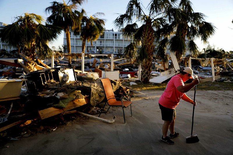 Peggy Cauley sweeps debris from the remnants of her family’s home Saturday in Mexico Beach, Fla.  