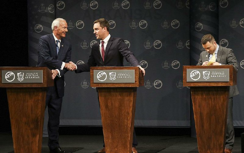 Arkansas Democrat-Gazette/MITCHELL PE MASILUN -- 10/12/2018 --
(L to R) Candidates for governor Asa Hutchinson (R-incumbent) shakes hands with Jared Henderson (D), as Mark West (L) takes off his mic after a debate at the Donald W. Reynolds Performance Hall in Conway Friday, Oct 12, 2018.