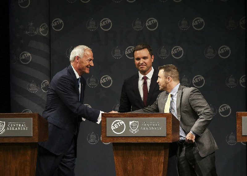 The three candidates for governor, Republican Gov. Asa Hutchinson,(from left) Democrat Jared Henderson and Libertarian Mark West, finish their debate Friday at the University of Central Arkansas in Conway. 