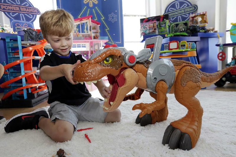 A child plays with a Jurassic World toy in August at a Walmart in New York. Walmart in November and December will call its toy areas “America’s Best Toy Shop” as it expands its toy assortment for the holiday season.